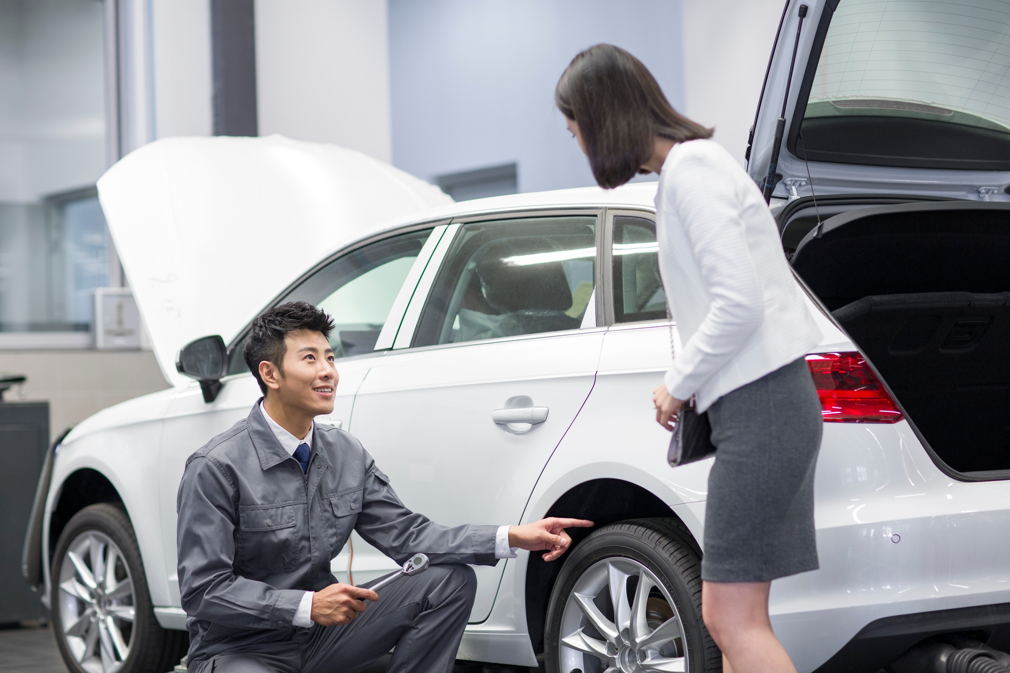 Auto mechanic talking with car owner